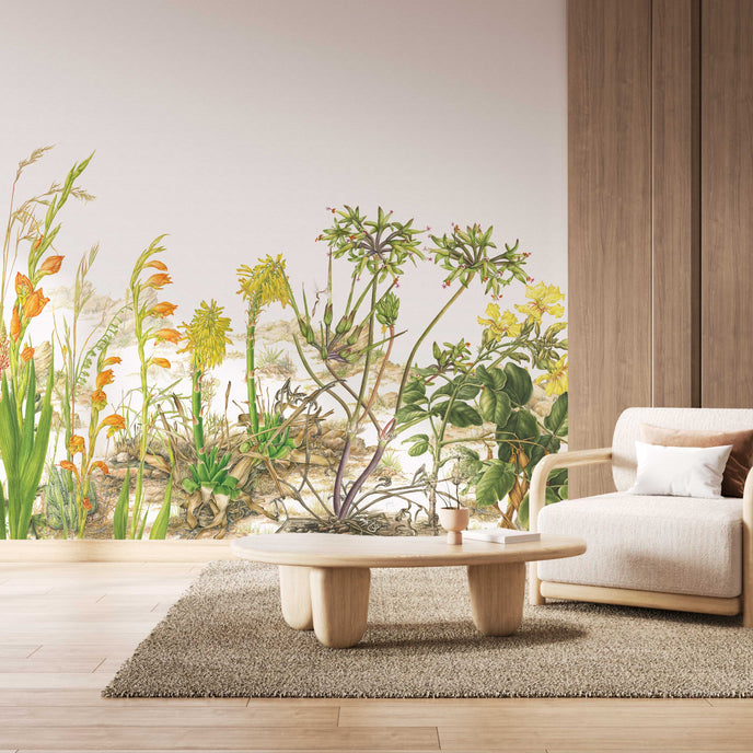 Botanical wallpaper mural featuring delicate South African flora and wildflowers in soft natural tones, with trailing greenery overhead and illustrated aloe, fynbos, and meadow plants across a light background. On a wall in a waiting area.