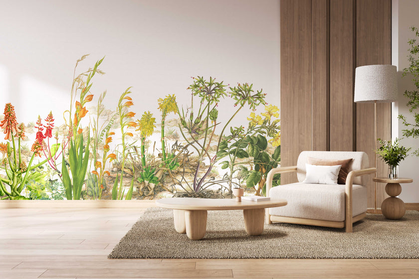 Botanical wallpaper mural featuring delicate South African flora and wildflowers in soft natural tones, with trailing greenery overhead and illustrated aloe, fynbos, and meadow plants across a light background. On a wall in a waiting area.