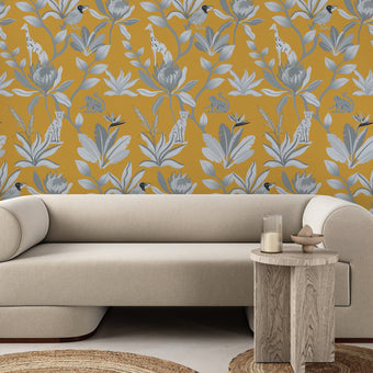 South African fynbos wallpaper pattern with protea flowers, birds and safari animals in an inspired botanical design. Black and white with mustard yellow background. On wall in a sitting room. 