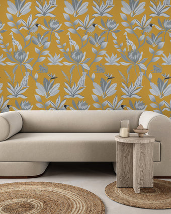 South African fynbos wallpaper pattern with protea flowers, birds and safari animals in an inspired botanical design. Black and white with mustard yellow background. On wall in a sitting room. 