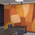 Shades of orange in abstract shapes with a paint brush texture. Blown up on wall in an office meeting room.