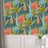 South African flower wallpaper with coral proteas, fynbos flowers, and layered foliage on a deep teal background. On wall above white paneling. 