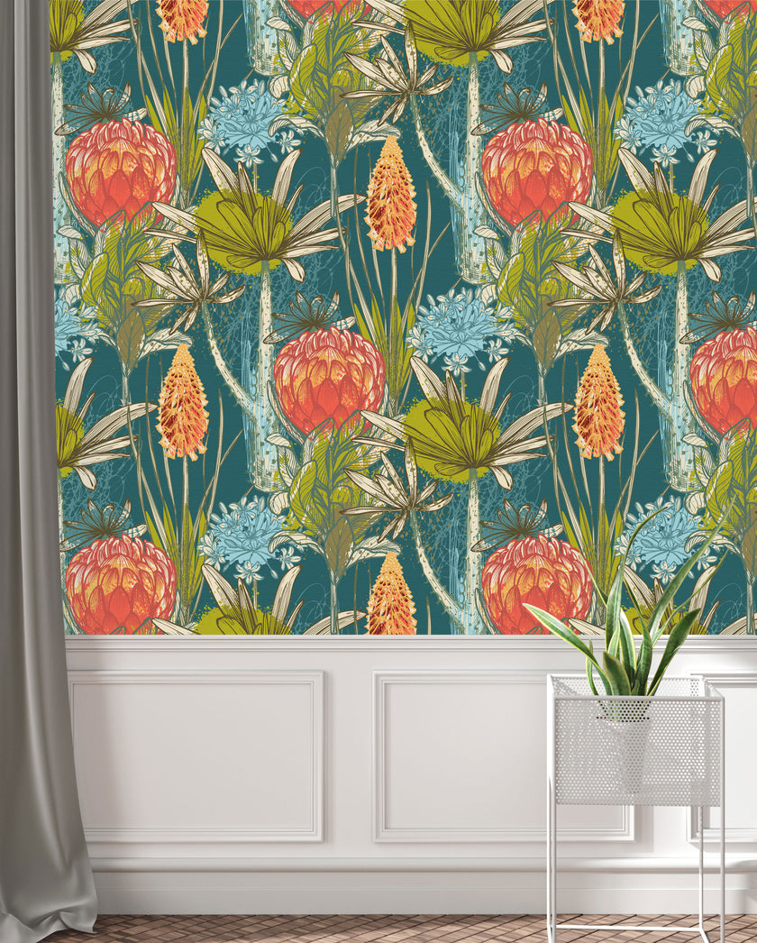 South African flower wallpaper with coral proteas, fynbos flowers, and layered foliage on a deep teal background. On wall above white paneling. 