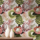 Botanical wallpaper with a seamless repeating pattern of hand painted blush pink proteas, cream anthuriums, and green foliage on a soft neutral background, styled behind a wooden cabinet with two white ceramic vases.
