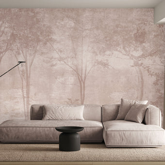 Blush toned forest mural featuring misty woodland trees and soft layered foliage in a dreamy, watercolour inspired style. On a wall in a lounge, behind the beige/cream couch. 