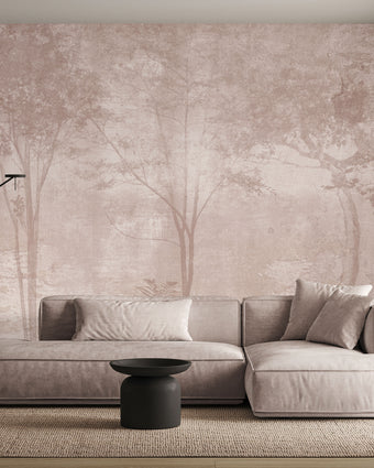 Blush toned forest mural featuring misty woodland trees and soft layered foliage in a dreamy, watercolour inspired style. On a wall in a lounge, behind the beige/cream couch. 