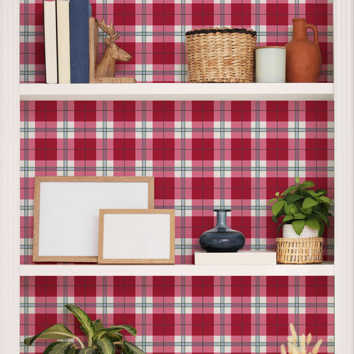 Playful pink tartan wallpaper with layered blush and red tones in a soft check design. Wallpaper behind shelves. 