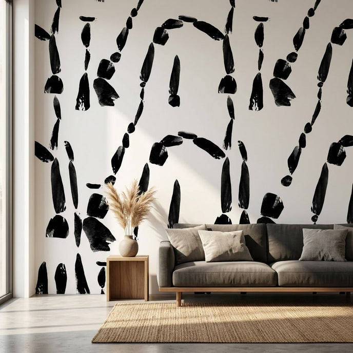 Custom printed Cairn wall mural with African-inspired geometric patterns in black and white, filling a modern living room wall.