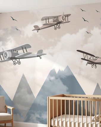 Vibrant large-scale children's nursery mural of a multicoloured airplane over mountains covering an entire wall.