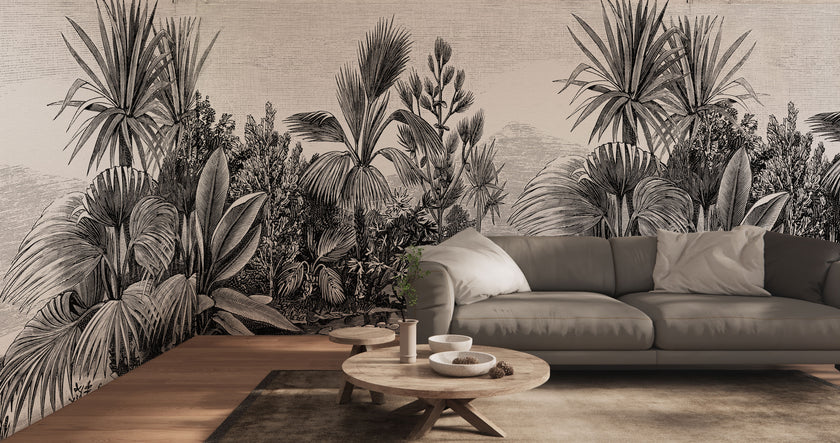 A large scale botanical wall mural featuring detailed black and white palm and tropical foliage, shown behind a grey sofa in a modern living room setting.