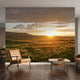 Large mural of a mountain sunset scene covering an entire wall with vibrant warm colors and seamless detail.