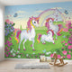 Realistic scene of a rainbow and unicorn mural on nursery wall, captured from a side angle for depth.