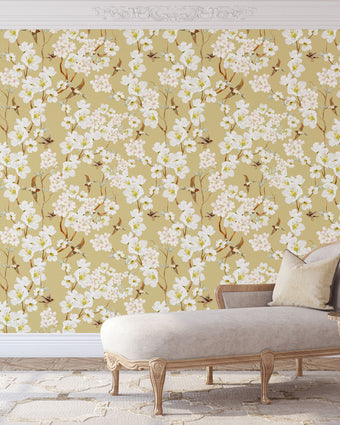 Vintage inspired wallpaper featuring white and blush blossom flowers, winding branches, and swallows in flight on a warm golden-beige background.