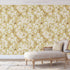 Vintage inspired wallpaper featuring white and blush blossom flowers, winding branches, and swallows in flight on a warm golden-beige background.