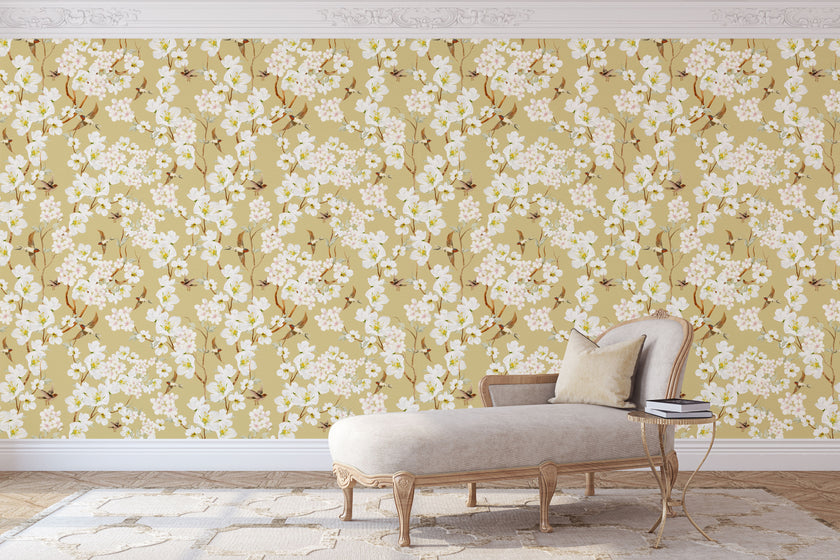 Vintage inspired wallpaper featuring white and blush blossom flowers, winding branches, and swallows in flight on a warm golden-beige background.