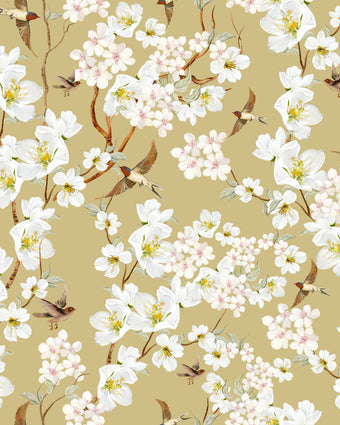 Vintage inspired wallpaper featuring white and blush blossom flowers, winding branches, and swallows in flight on a warm golden-beige background.