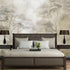 Soft neutral forest wallpaper featuring delicate misty trees in layered sepia and taupe tones with a hand sketched effect. On wall behind the bed.