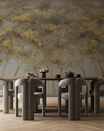 Forest mural featuring golden woodland trees with softly textured foliage against a smoky grey background, creating a warm and atmospheric nature inspired scene. On a wall behind a dinning table with dark furniture. 