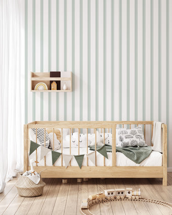 Classic green pinstripe wallpaper with fine vertical stripes, inspired by traditional country house interiors and timeless textile patterns. On kids bedroom wall, behind bed. 