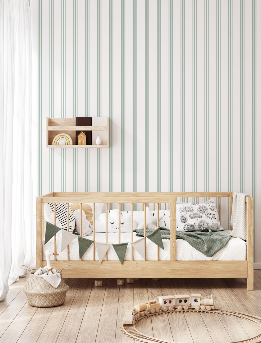 Classic green pinstripe wallpaper with fine vertical stripes, inspired by traditional country house interiors and timeless textile patterns. On kids bedroom wall, behind bed. 
