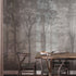 Nature-inspired forest mural featuring misty woodland trees in soft grey tones, creating a calm and atmospheric backdrop for contemporary interiors. On wall in a dinning room, with dark wooden table and chairs. 