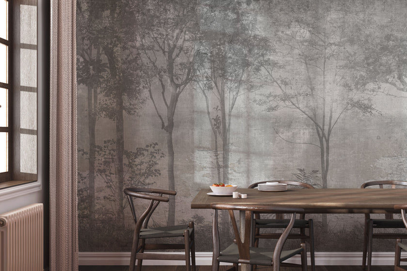 Nature-inspired forest mural featuring misty woodland trees in soft grey tones, creating a calm and atmospheric backdrop for contemporary interiors. On wall in a dinning room, with dark wooden table and chairs. 
