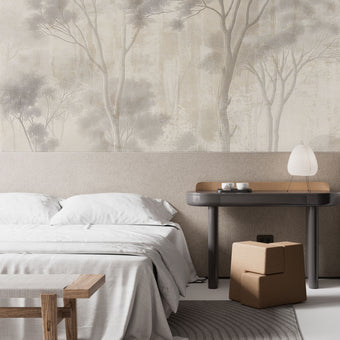 Neutral woodland wallpaper with soft ivory and taupe trees in a misty forest landscape. In a bedroom behind the beds headboard. 