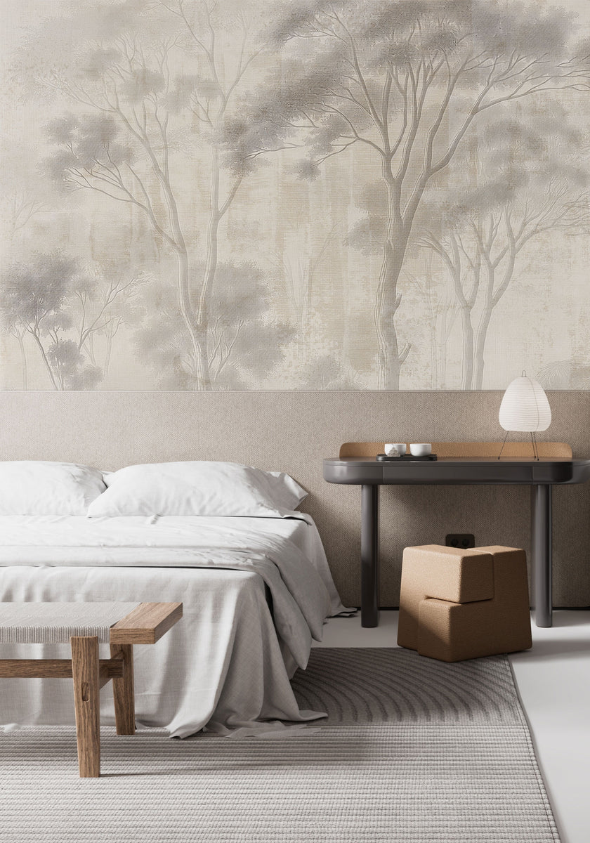 Neutral woodland wallpaper with soft ivory and taupe trees in a misty forest landscape. In a bedroom behind the beds headboard. 