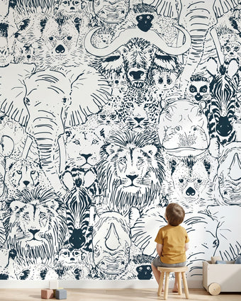 Full wall African animal mural in a kids' playroom featuring seamless elephants, giraffes, zebras, and white design elements.