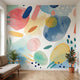 Cinematic shot of a large teal watercolour mural dominating a modern room wall.