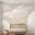Full-wall view of 'Daydream Haze' mural with beige clouds in a bright nursery, emphasizing detailed textures and pattern coverage.