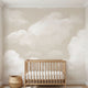 Full-wall view of 'Daydream Haze' mural with beige clouds in a bright nursery, emphasizing detailed textures and pattern coverage.