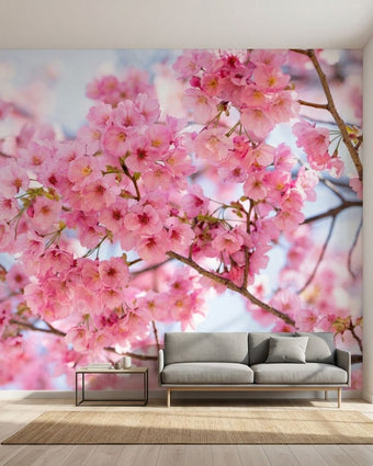Vibrant 'Mankai' cherry blossom mural on a large living room wall with natural daylight highlighting the floral design.