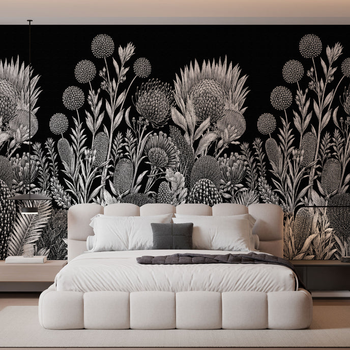 A modern bedroom featuring a large black wall mural with a detailed white botanical and floral pattern behind a low white platform bed.
