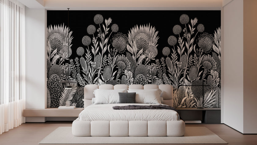 A modern bedroom featuring a large black wall mural with a detailed white botanical and floral pattern behind a low white platform bed.
