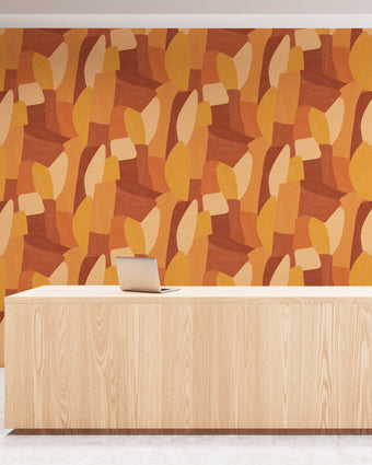 Shades of orange in abstract shapes with a paint brush texture. On wall in an office reception room.