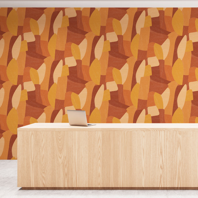 Shades of orange in abstract shapes with a paint brush texture. On wall in an office reception room.