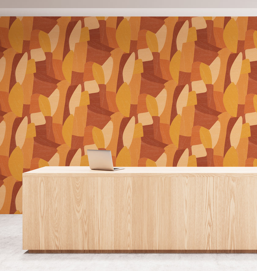 Shades of orange in abstract shapes with a paint brush texture. On wall in an office reception room.