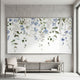 Medium shot of 'Forget Me Not' floral mural in a modern living room, emphasizing pattern details and textured surface with bright lighting.