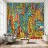 Vibrant multicoloured cityscape wall mural in a modern living room with natural daylight, emphasizing urban nightlife scene and detailed textures.