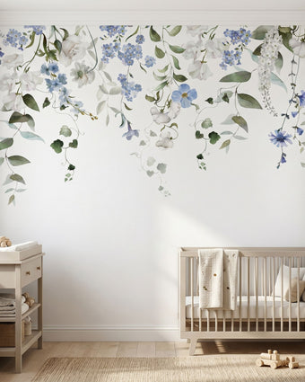 Full view of nursery wall decorated with 'Forget Me Not' floral mural showing seamless pattern on textured surface in natural light.