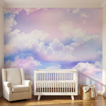 Colorful sky and cloud mural filling a nursery wall edge-to-edge with warm natural lighting, emphasizing its size and vibrant hues.