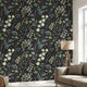 Close-up of the 'On a Whimmmm' seamless floral mural on a textured living room wall, showing vibrant sage green and black patterns with a join-free design.