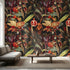 Delicate wall mural featuring Persiphone floral pattern with orchids and pomegranates in black and red, covering a smooth, neutral-toned wall in a modern living room.