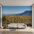 Lifelike mural of towering mountains, flowing river, and green foliage, filling the wall with vivid sky and crisp details.