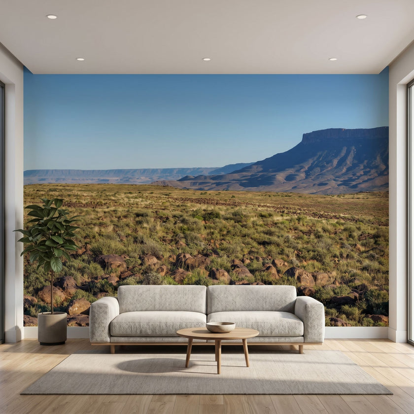 Lifelike mural of towering mountains, flowing river, and green foliage, filling the wall with vivid sky and crisp details.