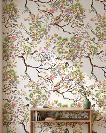 Close-up of 'Spring Renewal' mural featuring multicolored birds and floral patterns on textured living room wall, with natural light highlighting details.