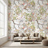 Vibrant floral mural with birds and branches in a bright living room setting, showcasing scale and detailed botanical pattern.