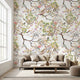 Vibrant floral mural with birds and branches in a bright living room setting, showcasing scale and detailed botanical pattern.