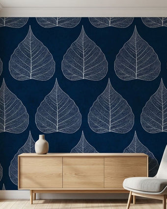 Close-up of the Traces floral mural on a wall showing blue leaves and seamless pattern in a modern living room setting.